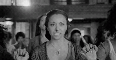 Black And White Photo Of Woman In Crowd Holding Hands Together GIF