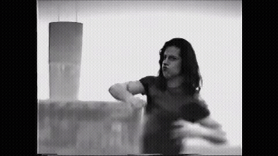 Black And White Photo Of Woman In Front Of Tower Building GIF