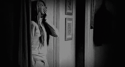 Black And White Photo Of Woman Looking Out Doorway GIF