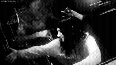 Black And White Photo Of Woman Sitting In Dark Room GIF