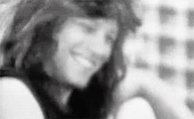 Black and White Photo of Woman Smiling in Room