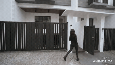 Black And White Photo Of Woman Walking In Front Of Building Made In Animatica GIF