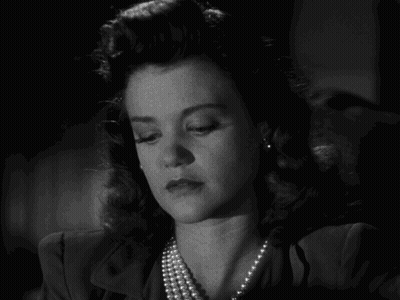 Black And White Photo Of Woman With Pearl Necklace And Earrings GIF