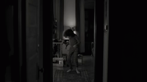 Black And White Photo Of Young Boy In Dark Room GIF