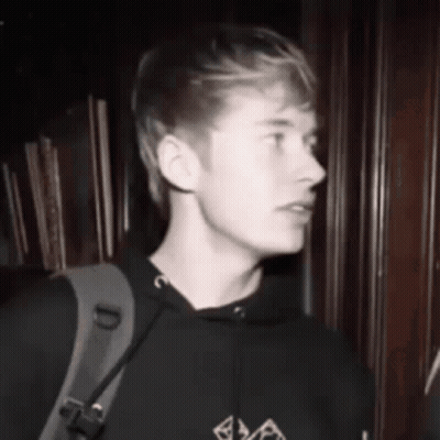 Black And White Photo Of Young Man In Hoodie With Backpack GIF