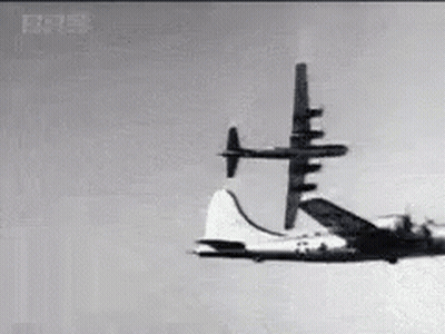 Black And White Plane Flying Through Blue Sky GIF