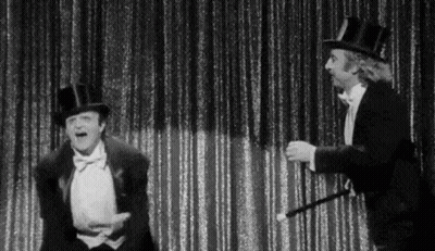 Black And White Two Men In Top Hats And Tuxedos On Stage GIF