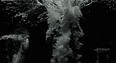 Black And White Wave Crashing On Rocky Shore GIF