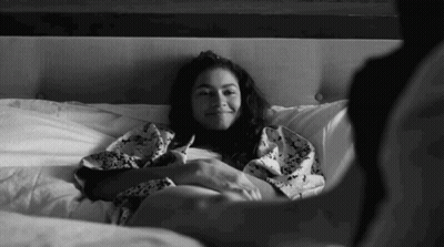 Black And White Woman Laying On Bed With Man GIF