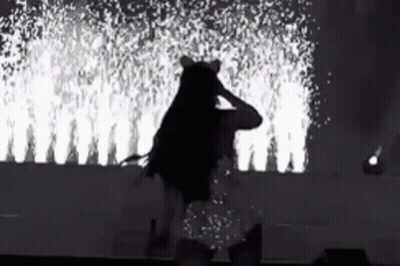 Black And White Woman On Stage With Fireworks GIF