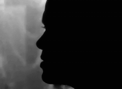 Black And White Woman's Face In Dark GIF