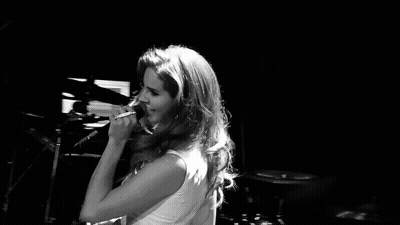 Black And White Woman Singing Into Microphone On Stage GIF