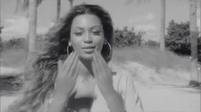 Black And White Woman With Hoop Earrings Touching Face GIF