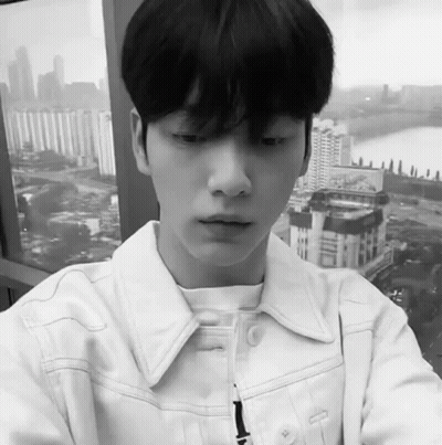 Black And White Young Man In White Jacket Looking Out Window GIF