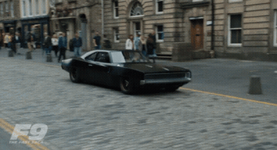 Black Car Driving On Cobblestone Street GIF