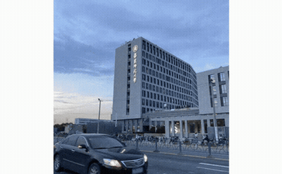 Black Car Driving Past Building With Chinese Writing GIF