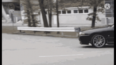 Black Car Driving Past White Fence GIF