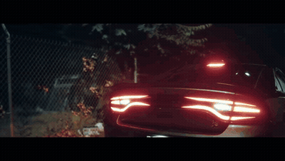 Black Car Parked In Front Of Fence GIF