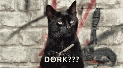 Black Cat Holding Scissors In Front Of Brick Wall GIF