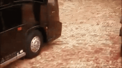 Black Limousine Driving On Cobblestone Street GIF
