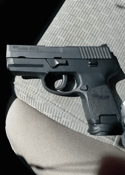 Black Sig Sauer Pistol On Lap GIF