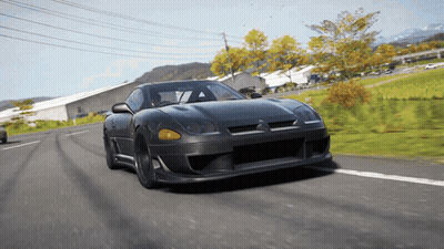 Black Sports Car Driving Down Road Near Field GIF
