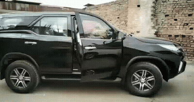Black SUV Parked In Front Of Brick Wall GIF