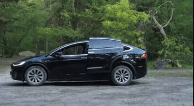 Black Tesla Model X Parked On Dirt Road With Doors Open GIF