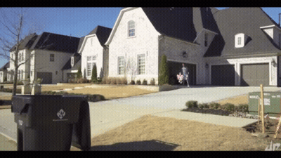 Black Trash Can With Diamond Logo In Front Of House GIF