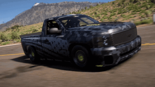 Black Truck Driving Down Road In Front Of Mountains GIF