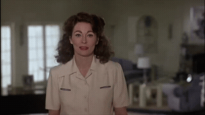 Blonde Curly Hair Woman Getting Hair Done With Pearl Necklace GIF