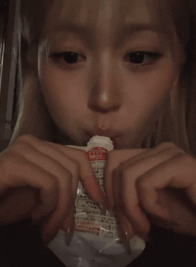 Blonde Girl Eating From Plastic Bag With Chinese Writing GIF