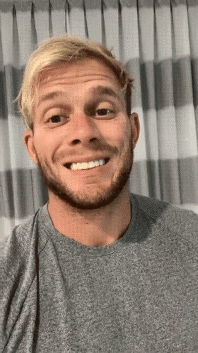 Blonde Haired Man With Beard Smiling In Front Of Curtain GIF