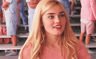 Blonde In Pink Shirt On Bench Facing Crowd GIF