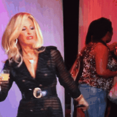 Blonde Woman In Black Dress Holding Drink GIF