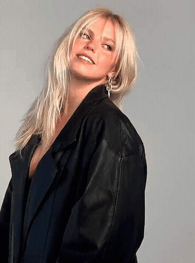Blonde Woman In Black Leather Jacket And Earrings GIF