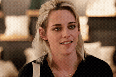 Blonde Woman In Black Shirt And Necklace Smiling GIF