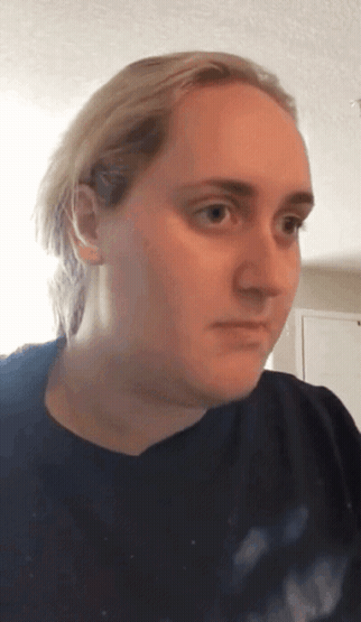 Blonde Woman In Black Shirt Looking At Camera GIF