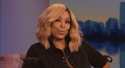 Blonde Woman In Black Shirt Making Funny Face On Couch GIF