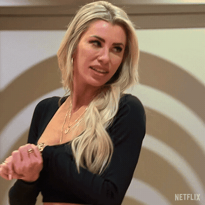 Blonde Woman In Black Top In Front Of Netflix Logo GIF