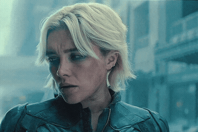 Blonde Woman In Blue Jacket And Earrings GIF