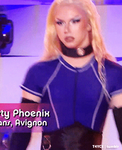 Blonde Woman In Blue Shirt And Black Gloves In Front Of Phoenix And Avignon Sign GIF