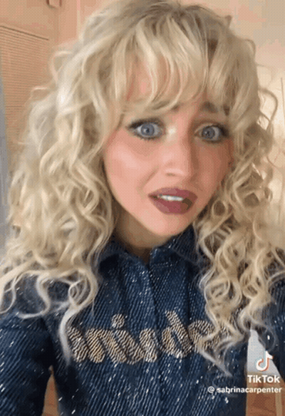 Blonde Woman In Denim Shirt Making Funny Face GIF
