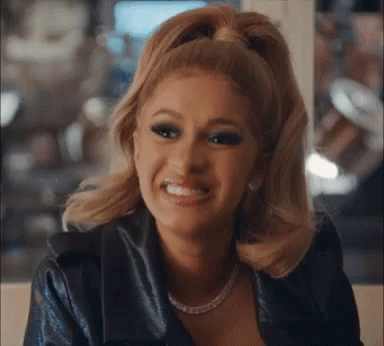 Blonde Woman In Ponytail Smiling In Leather Jacket And Pearl Necklace GIF