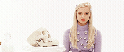 Blonde Woman In Purple Sweater Next To Skull GIF