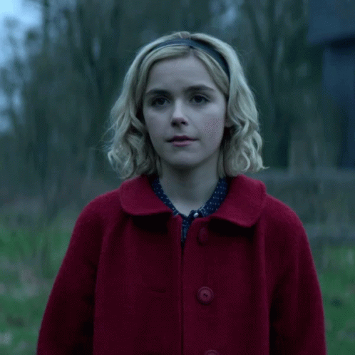 Blonde Woman In Red Coat And Headband Smiling GIF