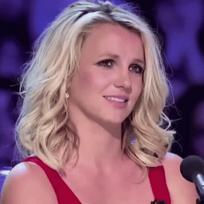 Blonde Woman In Red Dress Smiling At Microphone GIF