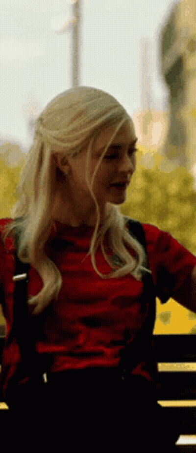 Blonde Woman In Red Shirt Sitting On Bench GIF