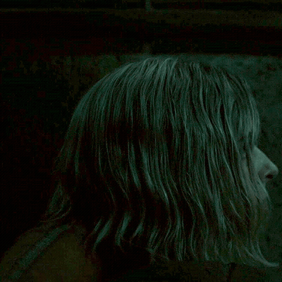 Blonde Woman Looking At Camera In Dark Room GIF