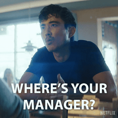 Blonde Woman Saying Because I'm The Manager In Front Of Shelf GIF